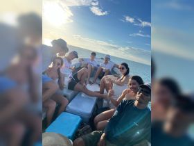 A lively group enjoys a fun day on the boat, celebrating with drinks and laughter under the sun — perfect for memorable outings with friends.