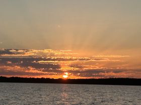 A stunning sunset over the water, casting vibrant colors across the sky — a perfect backdrop for evening boat cruises.