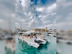 A lively group enjoys a celebration aboard the Big Mike catamaran, showcasing the perfect atmosphere for parties and gatherings on the water.