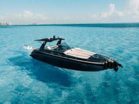 A stunning aerial view of a sleek speedboat gliding through crystal-clear waters, showcasing the beauty of a perfect day on the water.