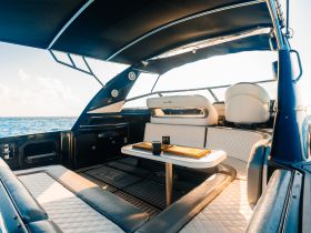 A stylish interior view of a boat's cabin featuring comfortable seating and a helm area, perfect for relaxing while enjoying the open water.