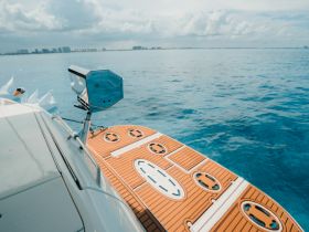 A detailed view of a boat's deck featuring a floating mat and onboard equipment, set against a tranquil ocean backdrop — perfect for leisurely days on the water.