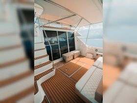 A spacious and inviting interior of a boat featuring comfortable seating and a well-designed helm area, perfect for relaxing or navigating the waters.