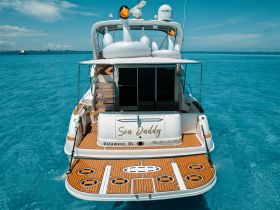 A stunning view of the 'Sea Daddy' yacht, showcasing its elegant design and spacious deck against a backdrop of crystal-clear waters.