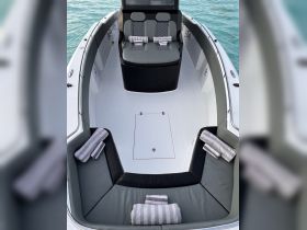 An inviting interior view of a boat's seating area, featuring comfortable cushions and neatly arranged towels, perfect for relaxing on the water.