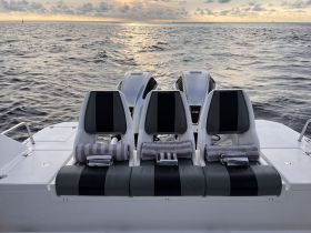 A sleek interior view of a boat's seating area, featuring comfortable seats and neatly arranged towels, perfect for a day on the water.