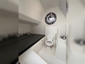 Interior view of a boat's bathroom area featuring a toilet and seating, showcasing the functional design of onboard amenities.