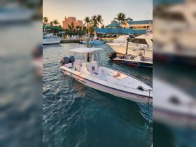 A sleek speedboat named 'Serratus' docked in a vibrant marina, surrounded by palm trees and colorful buildings, perfect for water adventures.
