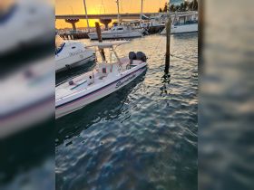 A beautiful speedboat named 'Seaworthy' docked at sunset, showcasing its sleek design and vibrant colors against the shimmering water.