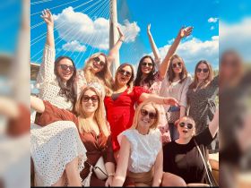 A lively group of friends celebrates together outdoors, showcasing joy and camaraderie against a beautiful backdrop. Perfect for capturing memorable moments during a fun outing.