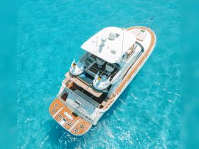 A stunning aerial view of a luxurious yacht cruising through crystal-clear waters, showcasing its elegant design and inviting deck space.