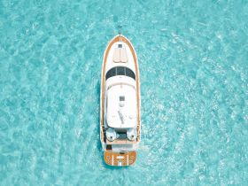 A stunning aerial view of a yacht cruising through crystal-clear turquoise waters, perfect for showcasing luxury boating experiences.