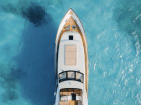 A stunning aerial view of a luxurious yacht gliding over crystal-clear turquoise waters, perfect for showcasing high-end boating experiences.