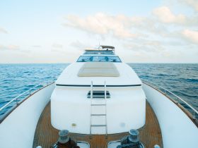 A stunning view of a yacht's bow cutting through the serene waters, showcasing its elegant design and inviting atmosphere for a perfect day on the sea.