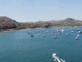 Aerial view of a serene marina filled with various boats anchored in calm waters, showcasing the beauty of coastal boating destinations.