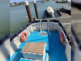Interior view of a boat's deck featuring seating and storage areas, ideal for relaxing while enjoying a day on the water.