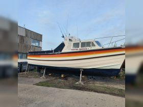 The Kestrel Warrior 7 is showcased in dry dock, highlighting its vibrant colors and sturdy design, perfect for fishing or leisure activities.