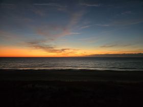 A stunning sunset over the ocean, casting vibrant colors across the sky and reflecting on the water — a perfect backdrop for evening boat adventures.