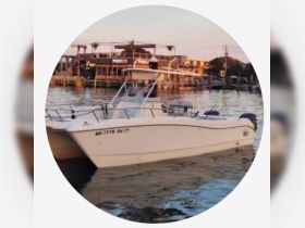A sleek speedboat docked in calm waters, showcasing its elegant design against a picturesque sunset backdrop.