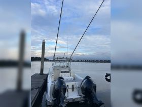A sleek speedboat docked at the marina, showcasing its powerful twin engines and fishing gear, perfect for a day out on the water.