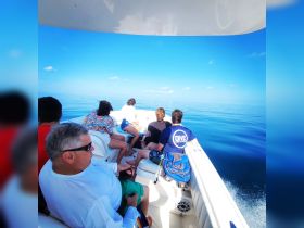 A group of friends enjoys a serene boat ride on calm waters, perfect for adventure seekers and ocean lovers.