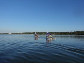 Two boats glide across calm waters, showcasing a fun day of boating with friends — perfect for summer adventures and water activities.