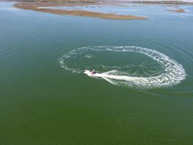A thrilling moment captured as a jet ski performs a circular maneuver on calm waters, showcasing the excitement of water sports.