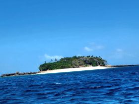 A stunning view of a secluded island surrounded by vibrant blue waters, perfect for exploring or relaxing on the beach.