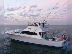 A group of anglers enjoys a fishing trip aboard a spacious boat during a beautiful sunset, showcasing the perfect blend of adventure and relaxation on the water.