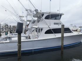 A side view of a fishing boat docked at the marina, showcasing its structure and fishing gear — perfect for deep-sea fishing adventures.