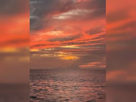 A breathtaking sunset paints the sky in vibrant hues over the ocean, creating a picturesque backdrop for evening boat trips and romantic getaways.