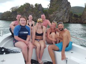 A cheerful group of friends enjoys their time on a boat, surrounded by stunning rock formations — perfect for memorable adventures and celebrations on the water.