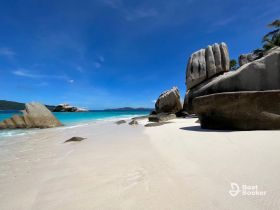 A stunning view of a pristine beach with unique rock formations and crystal-clear turquoise waters, perfect for a tropical getaway.