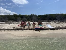 A group of friends enjoys a relaxing day at the beach, lounging on the sand and soaking up the sun — perfect for a fun getaway.