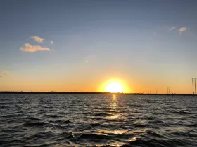 A serene sunset over the water, capturing the tranquil beauty of nature — perfect for evening boat cruises.