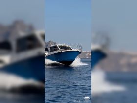 A sleek speedboat cuts through the water, showcasing its vibrant blue hull against a stunning backdrop — perfect for thrilling adventures on the open sea.