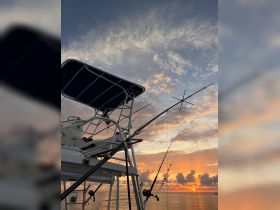 A stunning view of a fishing boat's helm against a vibrant sunset, showcasing the perfect setting for a day on the water.
