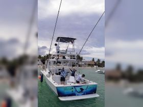 A lively group of anglers aboard a fishing boat prepares for an exciting day on the water, showcasing camaraderie and adventure in a picturesque ocean setting.