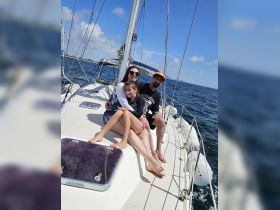 A joyful family enjoys a sunny day sailing on a boat, capturing precious moments together on the water.