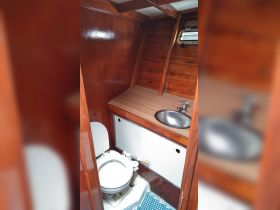 Interior view of a boat bathroom featuring a toilet and sink, showcasing the compact and functional design typical of marine cabins.