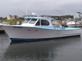 A sleek fishing boat named 'Fish-Finder' docked at the marina, showcasing its stylish design and readiness for fishing adventures.