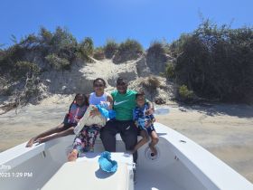 A joyful family enjoys a sunny day on their boat, creating lasting memories at the beach — perfect for family outings and adventures on the water.
