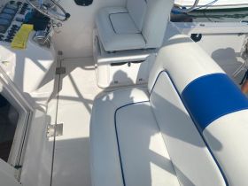 A clean and spacious interior view of a boat's helm and seating area, showcasing the modern design and comfort features ideal for a day on the water.