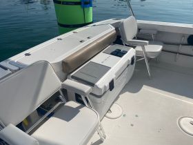 Interior view of a boat showcasing comfortable seating and a cooler, perfect for relaxing and enjoying refreshments while on the water.