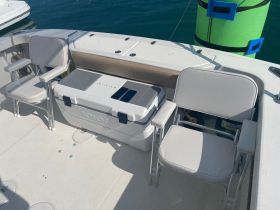 Interior view of a boat featuring comfortable seating and a cooler, perfect for relaxing during a day on the water.