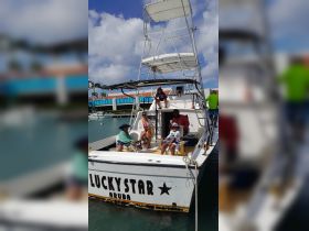 A family enjoys their time aboard the 'Lucky Star' boat in Aruba, creating unforgettable memories in a beautiful setting.