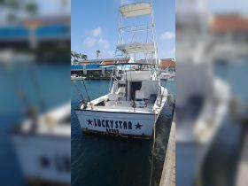 The 'LUCKY STAR' fishing boat is docked in Aruba, showcasing its sturdy design and fishing gear, perfect for adventurous outings on the water.