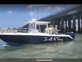 A group of anglers enjoy a day of fishing aboard the 'Just A Toy' boat, showcasing the excitement of on-water adventures.