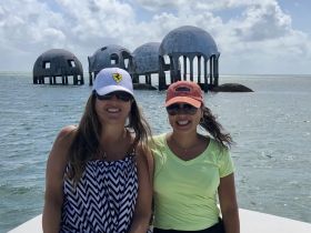 Two friends pose in front of the iconic underwater sculptures, enjoying a beautiful day on the water — a perfect backdrop for memorable adventures.