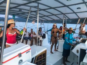 A lively group enjoys a festive atmosphere aboard a boat, with drinks in hand and smiles all around, perfect for a memorable celebration on the water.